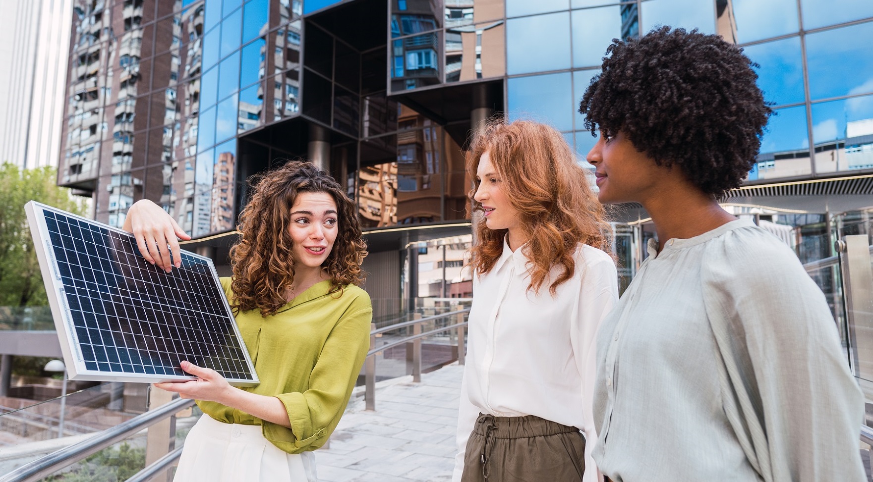 (Bild: © Frenchiebuddha – stock.adobe.com) Eine Expertin erklärt Passantinnen ein Solarpanel